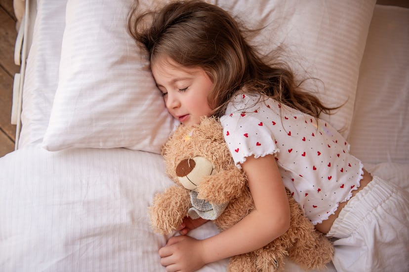 sleeping little girl with a teddy bear 