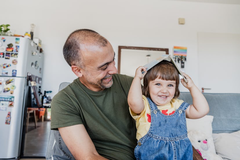 Baby girl having fun with father at home