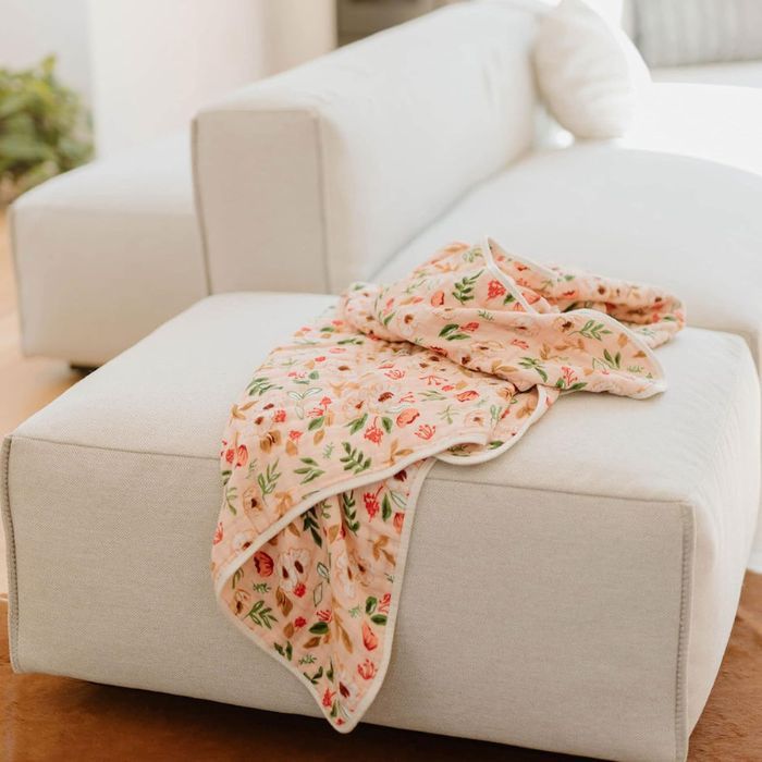 Little Unicorn Muslin Quilt Blanket on a couch