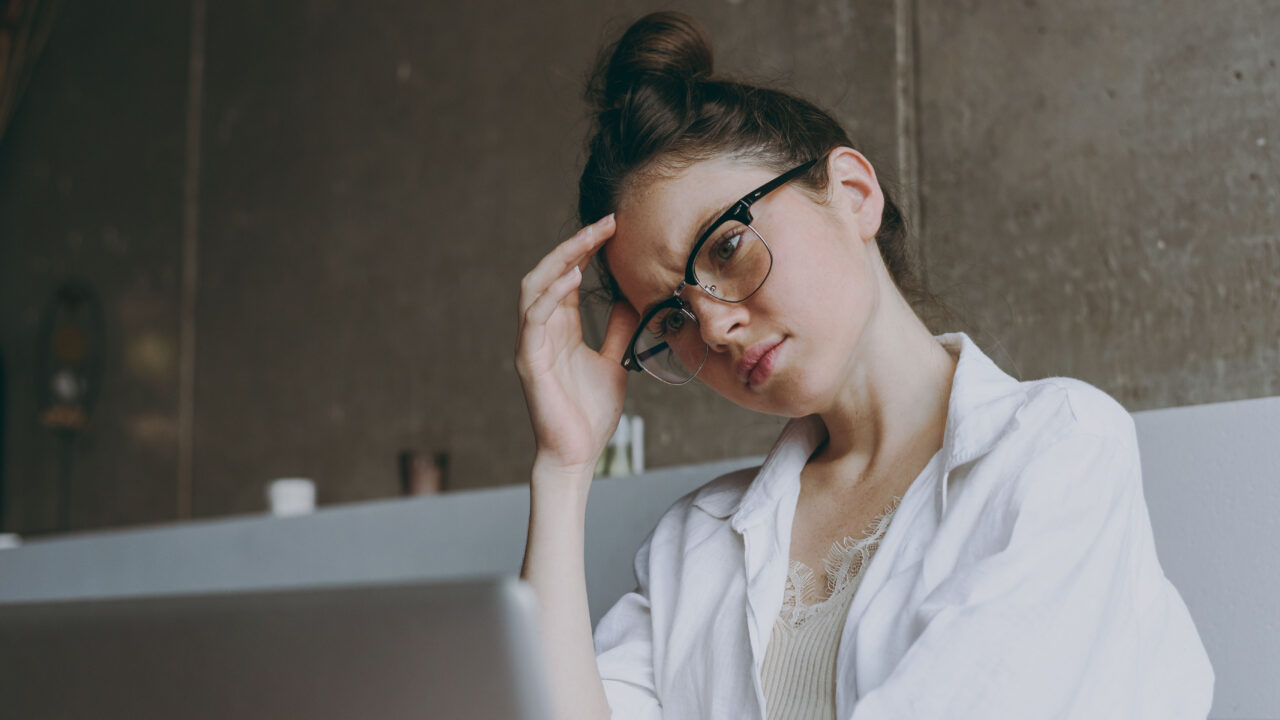 Thoughtful woman with laptop.