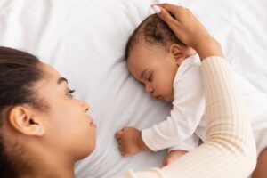 napping infant with mother