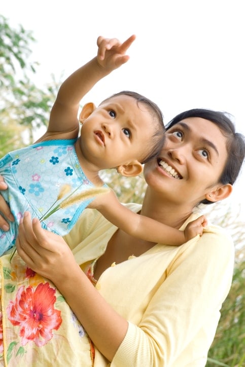 baby pointing up at sky, mother looks to see what baby is pointing at