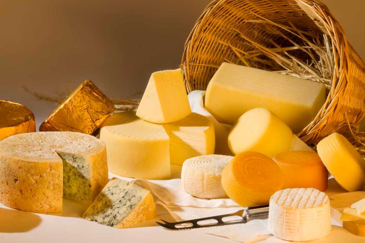 Different cheese products next to a basket.