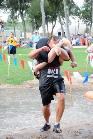 Man carrying woman upside down on his back in wife carrying race.