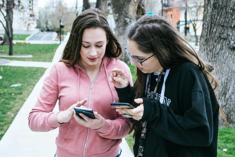 photo of mom and daughter using mobile phones