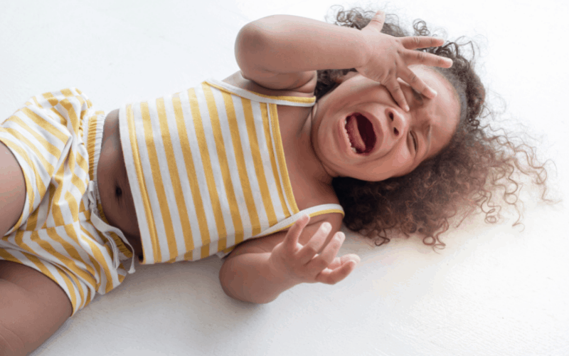 Girl is having a meltdown on the floor during a family gathering. 