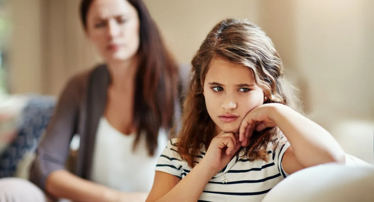 mother and daughter sitting on couch