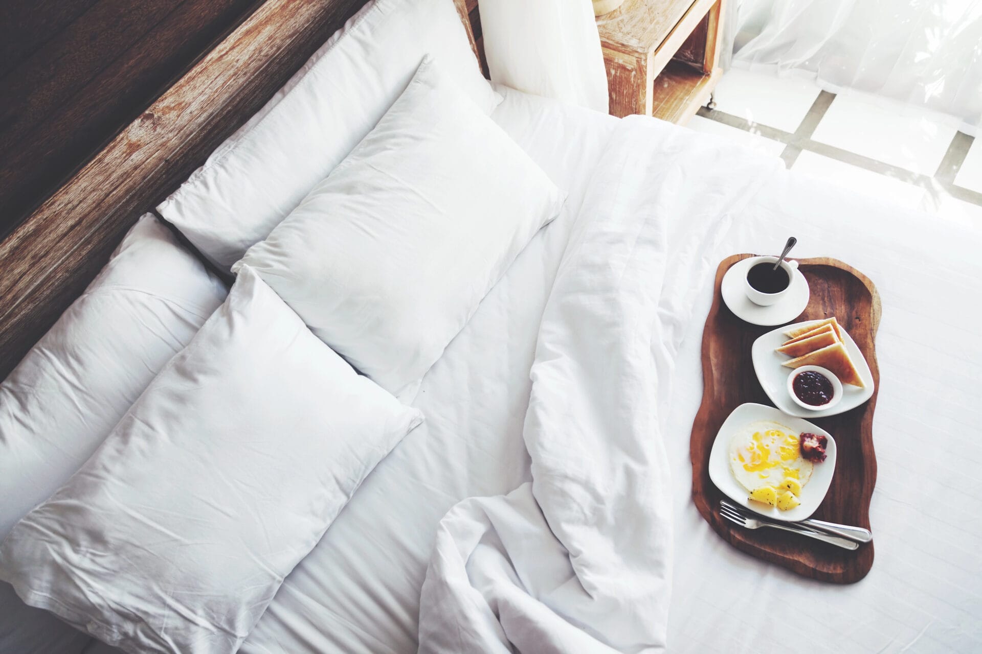 White bed with pillows and breakfast in bed