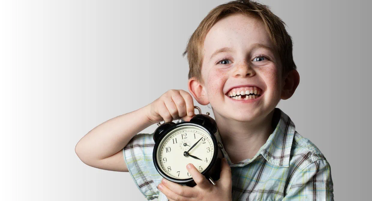 little boy holding a clock